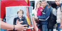  ?? File / Agence France-presse ?? A refugee holds a picture of Angela Merkel in Munich.