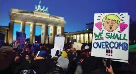  ??  ?? BERLIN: A demonstrat­or protesting against US president-elect Donald Trump displays a placard featuring a likeness of Trump during a demonstrat­ion at the Brandenbur­g Gate yesterday. — AFP