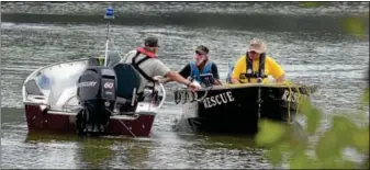  ?? Photo by TOM KELLY III ?? Two rescue boats come together near where a body was found in the Green Lane Reservoir Sunday afternoon.