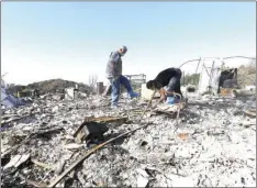  ?? PHOTO/JEFF CHIU ?? In this Tuesday photo, Timothy Lillyquist, (left) and Johnny Quirarte search through their friend Mary Burns’ home that was destroyed by wildfires in Santa Rosa. The drive to quickly rebuild homes for thousands of families in California’s most...