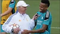  ?? MANU FERNANDEZ — THE ASSOCIATED PRESS ?? Real Madrid’s head coach Carlo Ancelotti, left, talks with Real Madrid’s Eder Militao during a Media Opening day training session in Madrid, Spain on Tuesday.