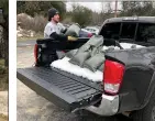  ?? ?? Ergastolo loads sandbags into atuolumne County resident’s pickup (below).