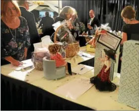  ??  ?? Guests occupy themselves before dinner by looking at silent auction items during the Frederick Living 120th Star-Studded Event.