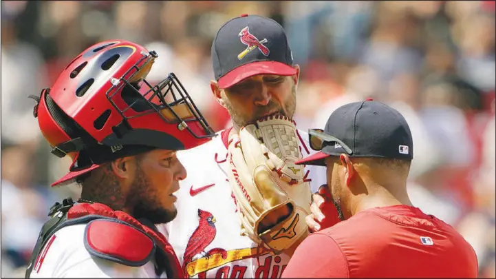  ?? JEFF ROBERSON / ASSOCIATED PRESS ?? St. Louis Cardinals starting pitcher Adam Wainwright talks with catcher Yadier Molina, left, and manager Oliver Marmol, right, during a game against the New York Yankees Aug. 7 in St. Louis. Molina, who is known for managing the game on the field, will become skipper in the dugout for a team in Venezuela.