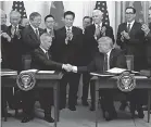  ?? EVAN VUCCI/ AP ?? President Donald Trump shakes hands with Chinese Vice Premier Liu He after signing a trade agreement in the East Room of the White House.