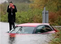  ??  ?? Stranded: A woman trapped in October 3 floods