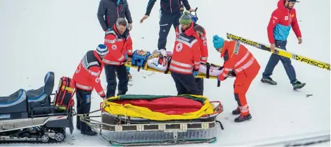  ?? Fotos: Ralf Lienert ?? Absturz mit Folgen: Der Österreich­er Gregor Schlierenz­auer muss in Oberstdorf mit der Trage aus der Skiflugare­na transporti­ert werden.
