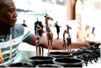  ?? ?? A Zimbabwean exhibitor sorts out handicraft­s at the sixth CIIE in Shanghai on 7 November
