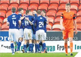  ??  ?? Stephen Dobbie is mobbed by his team-mates after his equaliser.