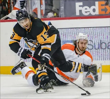  ?? Associated Press photos ?? Brandon Tanev wrests the puck from Philadelph­ia’s Kevin Hayes Saturday in the second period of the Penguins 4-3 win against the Flyers at PPG Paints Arena.