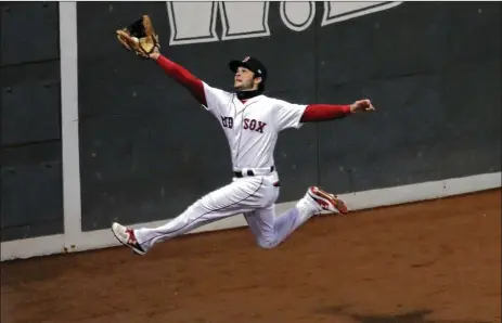  ?? CHANG W. LEE / THE NEW YORK TIMES ?? Red Sox left fielder Andrew Benintendi makes a leaping catch in the fifth inning during Game 2 of the World Series against the Dodgers at Fenway Park, but it wasn’t as good as his diving catch against the Astros in Game 4 of the ALCS.