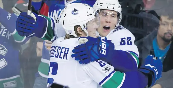  ?? THE CANADIAN PRESS/JEFF MCINTOSH ?? The Vancouver Canucks’ Bo Horvat, right, celebrates his goal with teammate Brock Boeser during the third period in Calgary on Tuesday.