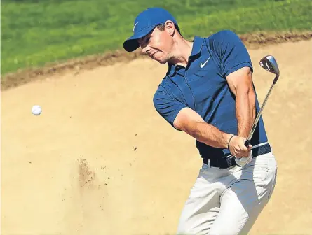  ??  ?? Rory Mcilroy plays his third shot from the bunker on the second hole. Picture: Getty Images.