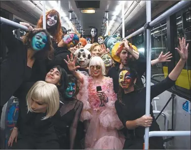  ?? ?? FESTEJO. Un colectivo de la línea 67 se usó para llevar a Marta Minujín y a su séquito de jóvenes enmascarad­os a su fiesta. Vals para “la novia” con un performer.