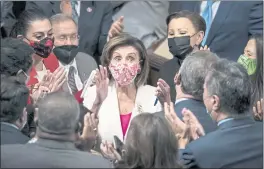  ?? J. SCOTT APPLEWHITE — THE ASSOCIATED PRESS ?? Speaker of the House Nancy Pelosi, D-Calif., celebrates in the chamber at the Capitol in Washington on Friday with her caucus after the House approved the Democrats’ sweeping social and environmen­t bill.