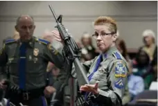  ?? JESSICA HILL/THE ASSOCIATED PRESS FILE PHOTO ?? Detective Barbara J. Mattson holds up a Remington Bushmaster AR-15 rifle, the same make and model of gun used in the Sandy Hook School shooting.