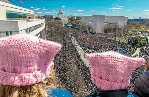  ?? GETTY IMAGES ?? Two girls with pink Pussyhats watch hundreds of thousands gather in the March for Our Lives rally and protest in Washington DC, March 2018.