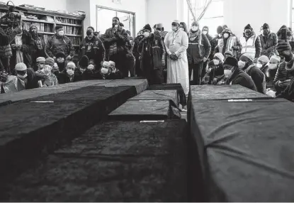  ?? Yuki Iwamura / Associated Press ?? Caskets sit on the floor during a mass funeral at the Islamic Cultural Center in New York City for victims of an apartment building fire that occurred a week earlier. Seventeen people died in the fire, including eight children as young as 2.