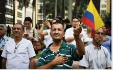  ?? LUIS ROBAYO Getty Images ?? In June 2016, people sing the national anthem in Cali, Colombia, as they celebrate the peace agreement between the government and the FARC leftist guerrilla group.