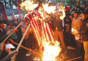  ?? AP PHOTO ?? Hardline Iranian demonstrat­ors burn representa­tions of the U.S. flag during a gathering in front of the former U.S. Embassy in Tehran, Iran, Wednesday.