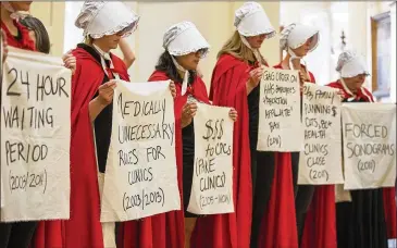  ?? RICARDO B. BRAZZIELL/AMERICAN-STATESMAN ?? Abortion-rights activists dressed as characters from Margaret Atwood’s “The Handmaid’s Tale,” now in a new TV adaptation, protest anti-abortion bills Tuesday in the state Capitol rotunda.