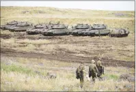  ?? AP PHOTO ?? Israeli soldiers walk past tanks in the Israeli- controlled Golan Heights, near the border with Syria, Thursday.