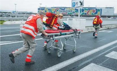  ?? (Christian Hartmann/Reuters) ?? A GURNEY is wheeled into the Orly airport southern terminal after a shooting incident near Paris yesterday.