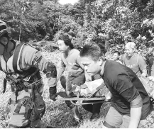  ??  ?? Mulu Park SAR team members carry Bevan’s body from Camp 5 to the helicopter.