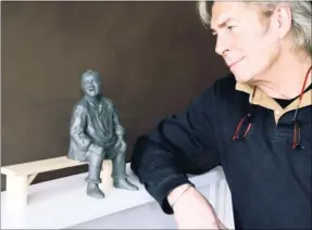  ??  ?? Sculptor Dominic Grant with the miniature of Dave Lee and the bench