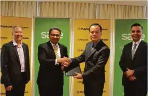  ??  ?? Maybank head of community financial services Datuk Hamirullah Boorhan (second from left) exchanging documents with Sage Software vice-president (Asia) Robin Chao in Kuala Lumpur recently.