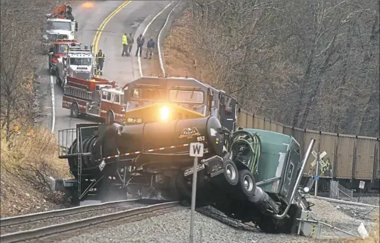  ?? Darrell Sapp/Post-Gazette ?? A tanker truck lies crushed in front of a locomotive pulling coal cars Tuesday along Route 88 in Centervill­e, Washington County.