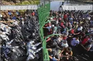  ?? MARCO UGARTE / ASSOCIATED PRESS ?? Central American migrants charge Mexican National Guardsmen at the border crossing between Guatemala and Mexico on Saturday.