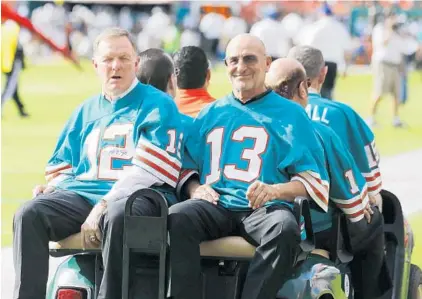  ?? JOHN BAZEMORE/AP ?? In this Dec. 16, 2012, file photo, Bob Griese (12) and Jake Scott of the 1972 Miami Dolphins, are driven onto the field for a halftime celebratio­n during the Dolphins’ game against the Jacksonvil­le Jaguars in Miami.