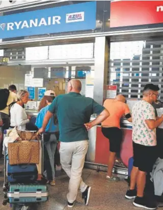  ?? // REUTERS ?? Un grupo de pasajeros reclaman en el aeropuerto de Málaga