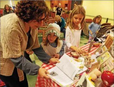  ?? LISA MITCHELL — DIGITAL FIRST MEDIA ?? Fleetwood resident Lisa Koncsics, left, brought her youngest daughter Charlotte, 7, center, to the Kutztown Community Library program “Beyond Little House” on Feb. 18. They are big fans of the “Little House” books.