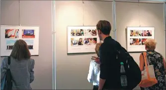  ?? PENG DAWEI / CHINA NEWS SERVICE ?? Visitors look at photos of an exhibition featuring China’s Belt and Road Initiative at the Chinese Culture Center in Berlin.