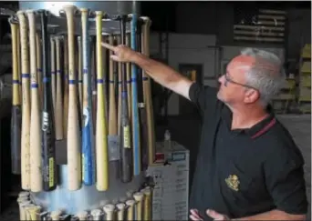  ?? PETE BANNAN — DIGITAL FIRST MEDIA ?? David Chandler headquarte­rs. points to size markings on sample bats at his company’s Norristown