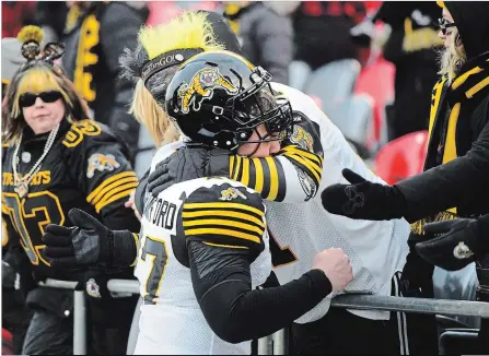  ?? SEAN KILPATRICK THE CANADIAN PRESS ?? Hamilton Tiger-Cats’ Aaron Crawford gets a hug from a fan after the team’s loss to the Redblacks in the CFL East Division final on Sunday in Ottawa. The Redblacks won 46-27.