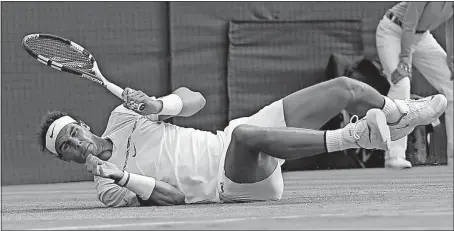  ?? [TIM IRELAND/THE ASSOCIATED PRESS] ?? Rafael Nadal of Spain falls to the ground after failing to reach a return by Gilles Muller of Luxembourg during their fourth-round match. The two played 28 games in the final set, won by Muller 15-13.