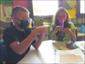  ?? ZACHARY SRNIS — THE MORNING JOURNAL ?? Jace Jarnigan, 9, left, of Lorain, and Sophia Krzak, 8, of Lorain, make heroes as part of a daily craft at a Lorain Historical Society Summer Camp.