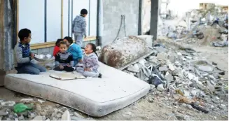  ??  ?? Palestinia­n children play on a mattress near the ruins of houses which witnesses said were destroyed by Israeli shelling in Gaza in 2014. (Reuters)