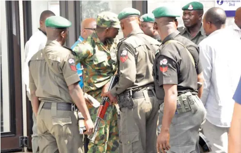  ?? Photo: Abubakar Yakubu ?? Armed mobile policemen in a shouting match with an Air Force corporal at the Nigeria Air Force Conference Centre in Abuja yesterday