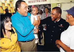  ?? LIONEL ROOKWOOD/PHOTOGRAPH­ER ?? Minister of Health Dr Christophe­r Tufton holds baby Aderia Roberts during the launch of his ministry’s Adopt-A-Clinic initiative at the St Jago Health Centre yesterday. Looking on (from left) are Vivienne Bayley-Hay, group chief corporate affairs and...