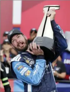  ?? CHUCK BURTON — THE ASSOCIATED PRESS ?? Martin Truex Jr struggles to raise the trophy in Victory Lane after winning a NASCAR Cup Series auto race at Charlotte Motor Speedway in Concord, N.C., Sunday.