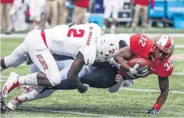  ?? AP FILE ?? Western Kentucky running back D’Andre Ferby (32) is tackled by Florida Atlantic Owls linebacker Azeez Al-Shaair (2) during an NCAA college football game.