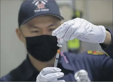  ?? Gary Coronado Los Angeles Times ?? AN LAFD paramedic prepares a COVID-19 vaccinatio­n. More than 1,000 Los Angeles Fire Department employees had not provided any informatio­n on their vaccinatio­n status as of this week, city figures indicated.