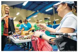  ?? AILEEN PERILLA/STAFF PHOTOGRAPH­ER ?? At a backpack-stuffing event Tuesday, volunteers gather to fill more than 700 backpacks, which will be donated to at risk students in Orange, Osceola and Seminole counties.