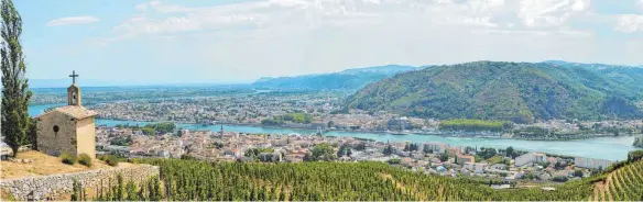  ?? FOTO: SHU ?? Weinfreund­e zieht es immer wieder hierher: An der Rhône, wie hier an den Weinhängen bei Tournon und Tain-l’Hermitage mit der Kapelle, gedeihen ganz besondere Gewächse.