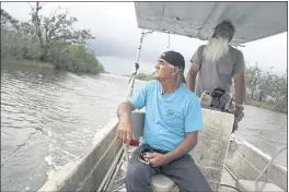  ?? JESSIE WARDARSKI — THE ASSOCIATED PRESS ?? Donald Dardar, left, and Russell Dardar look toward the eroding shoreline of Bayou Pointeau-Chien in southern Louisiana on Wednesday. The brothers have lived along the bayou all their lives as shrimpers and fishermen. They now also work to preserve the coastal land from further erosion by refilling canals and developing living shorelines.