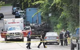  ?? BARBARA HADDOCK TAYLOR/BALTIMORE SUN ?? Baltimore City police work at a crime scene on the 200 block of Boswell Road in the southwest area of the city. A woman and a toddler were found fatally shot inside a car.